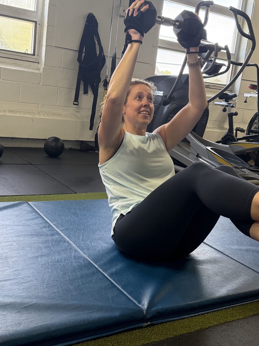 Bolt Fitness member doing a dumbbell press during a workout
