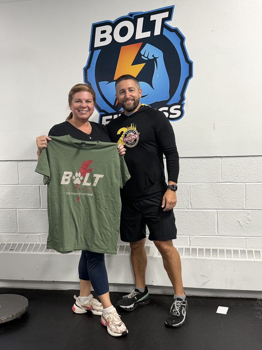 Carl with a Bolt Fitness member holding up a new Bolt Fitness t-shirt